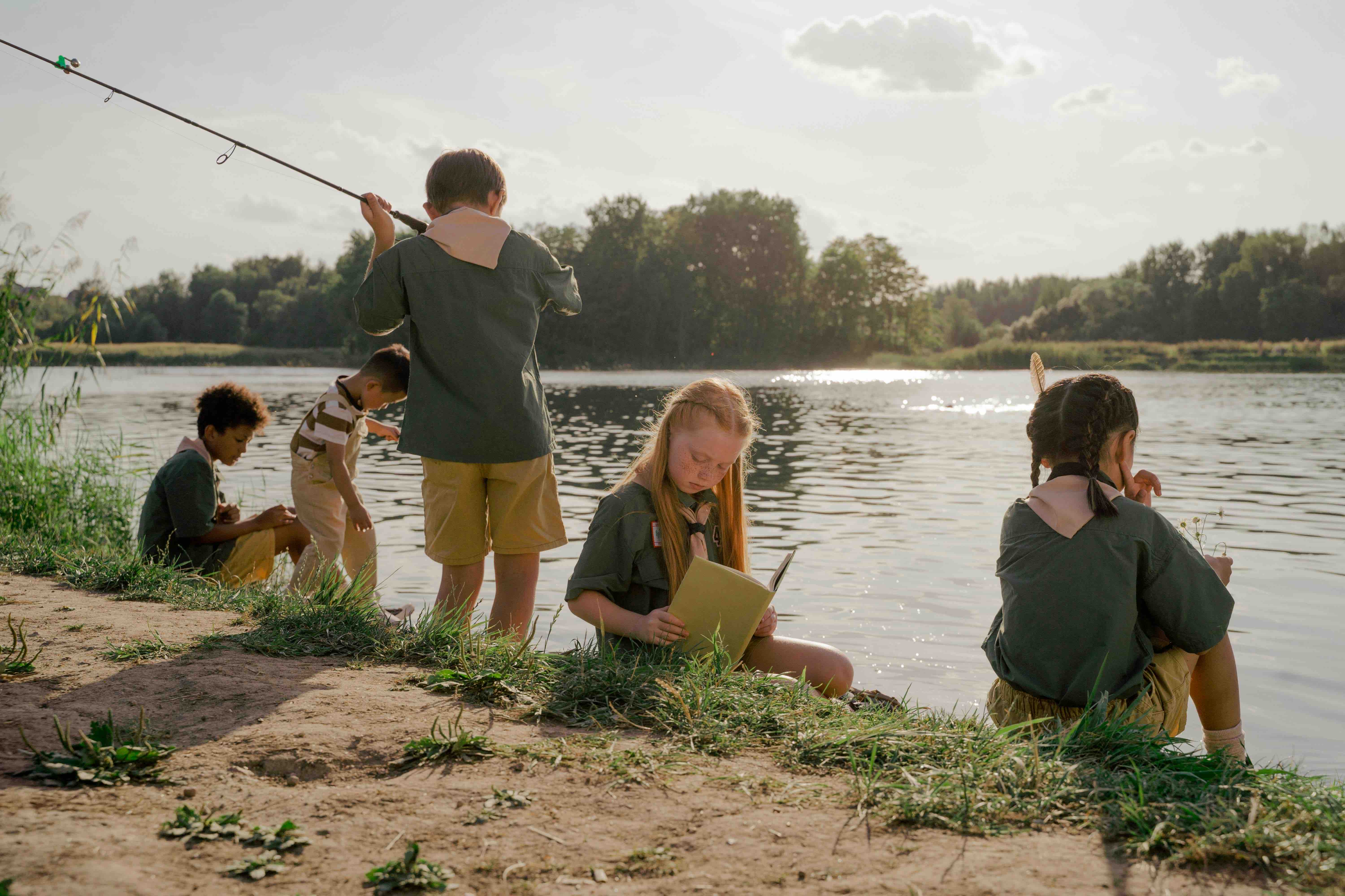 children fishing in a pond